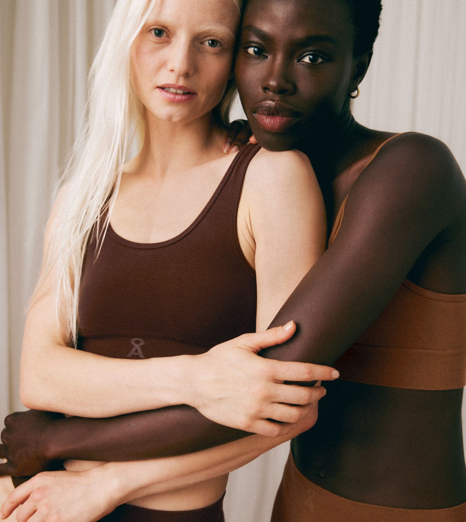 Zwei Personen umarmen sich und tragen braune Seamless-Unterwäsche aus der gleichen Kollektion.