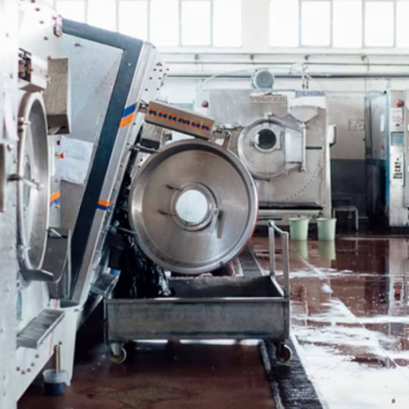 Industrielle Waschmaschinen in einer Textilfabrik, genutzt zur Denim-Verarbeitung.