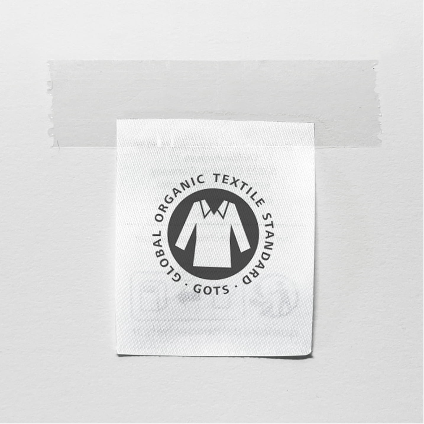 Etikett mit GOTS-Siegel „Global Organic Textile Standard“ auf hellem Hintergrund.
