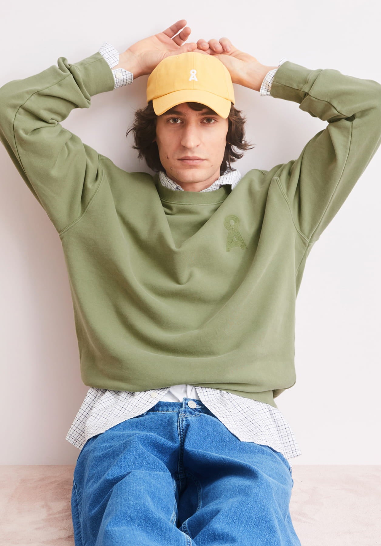 Model mit einem grünen SWeatshirt mit A-Logo